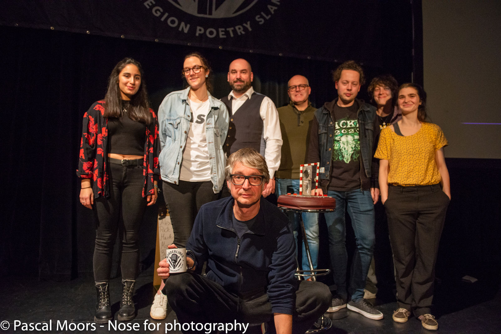 Borderlines - Euregion Poetry Slam 2019 | Finale: Destina Demir, Barbara Roherwasser, Alexander Bach, Markim Pause (op de voorgrond), Jan Widdershoven, Rik Sprenkels, Monique Hendriks, Jo An Westerveld. Foto: © Pascal Moors.